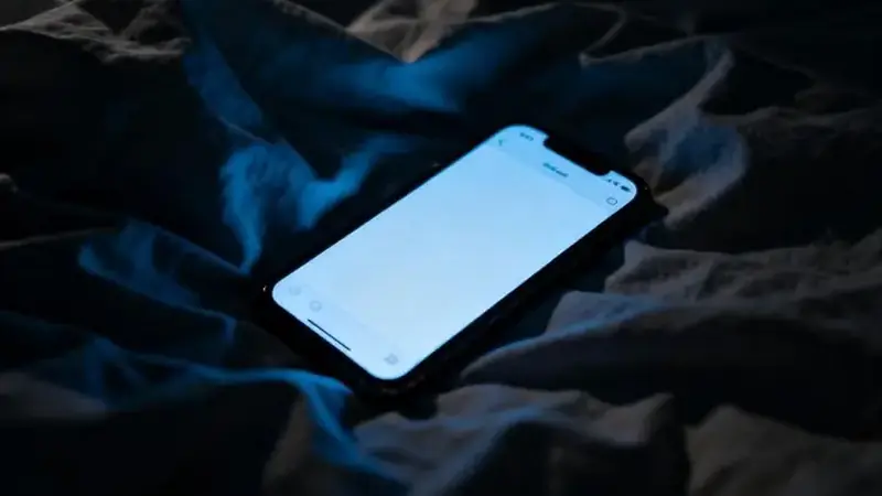 Glowing phone in a dark bedroom