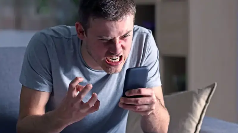 Frustrated person holding a lagging phone